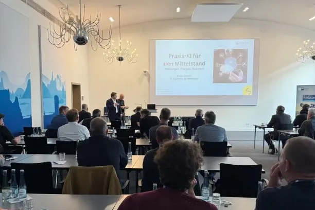 Full room at IHK Koblenz, the slide "Praxis-KI für den Mittelstand" on the screen